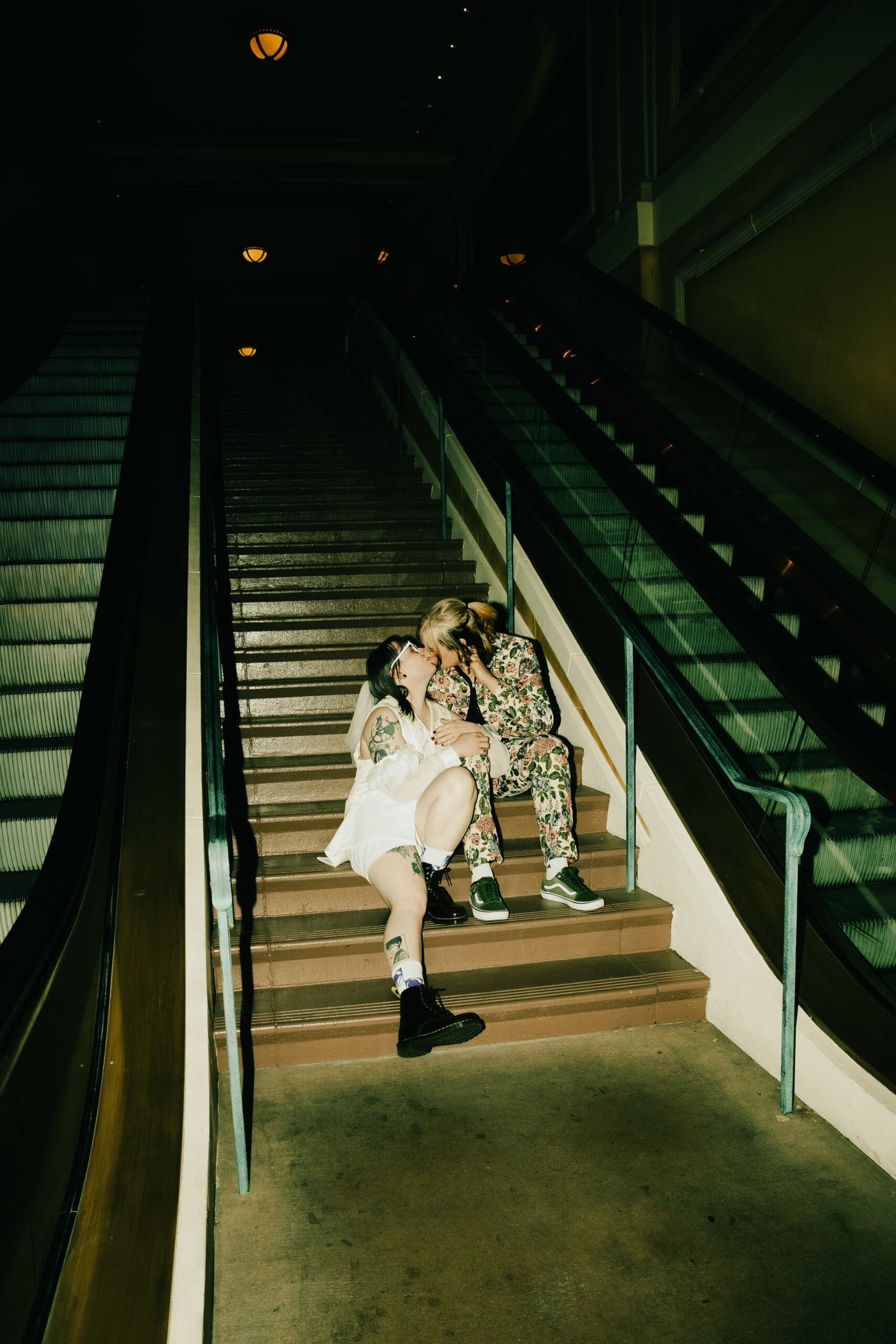 bride and groom share a candid kiss on the stairs