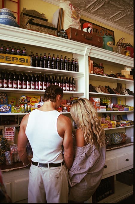 couple pose for photos together in a general store 