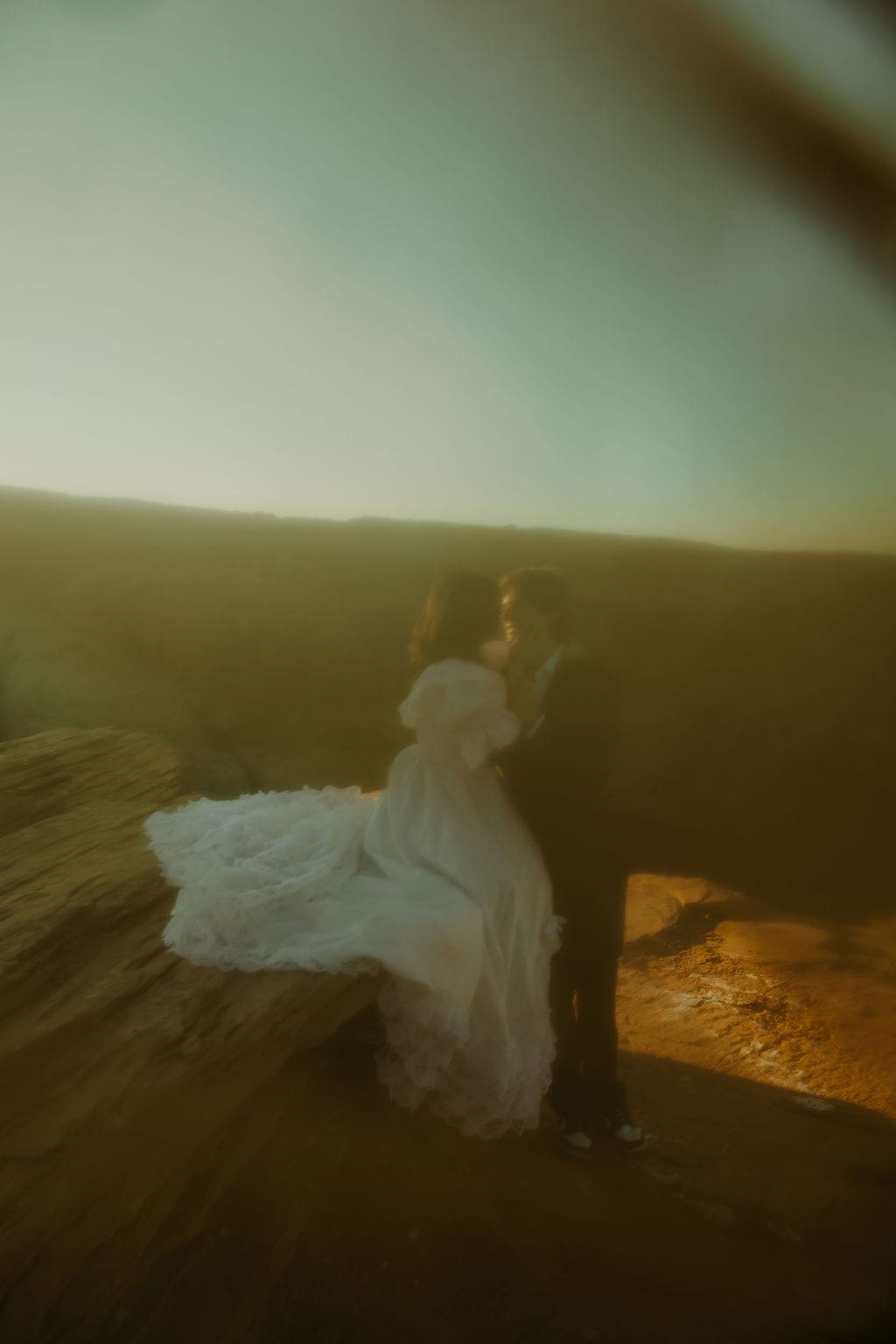 bride and groom share a romantic moment with the desert in the background