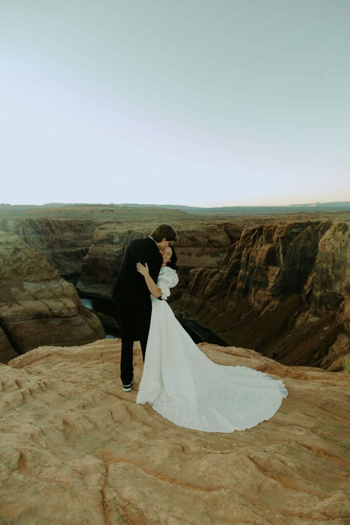 bride and groom pose on the overlook during their horseshoe bend elopement