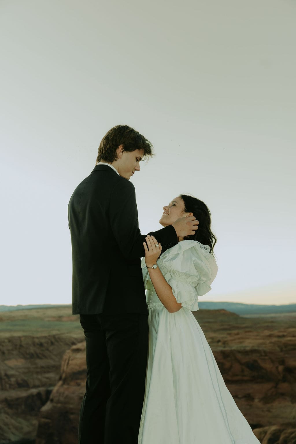 bride and groom share a romantic moment with the desert in the background