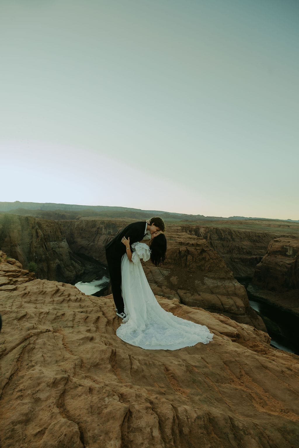 bride and groom pose on the overlook during their horseshoe bend elopement