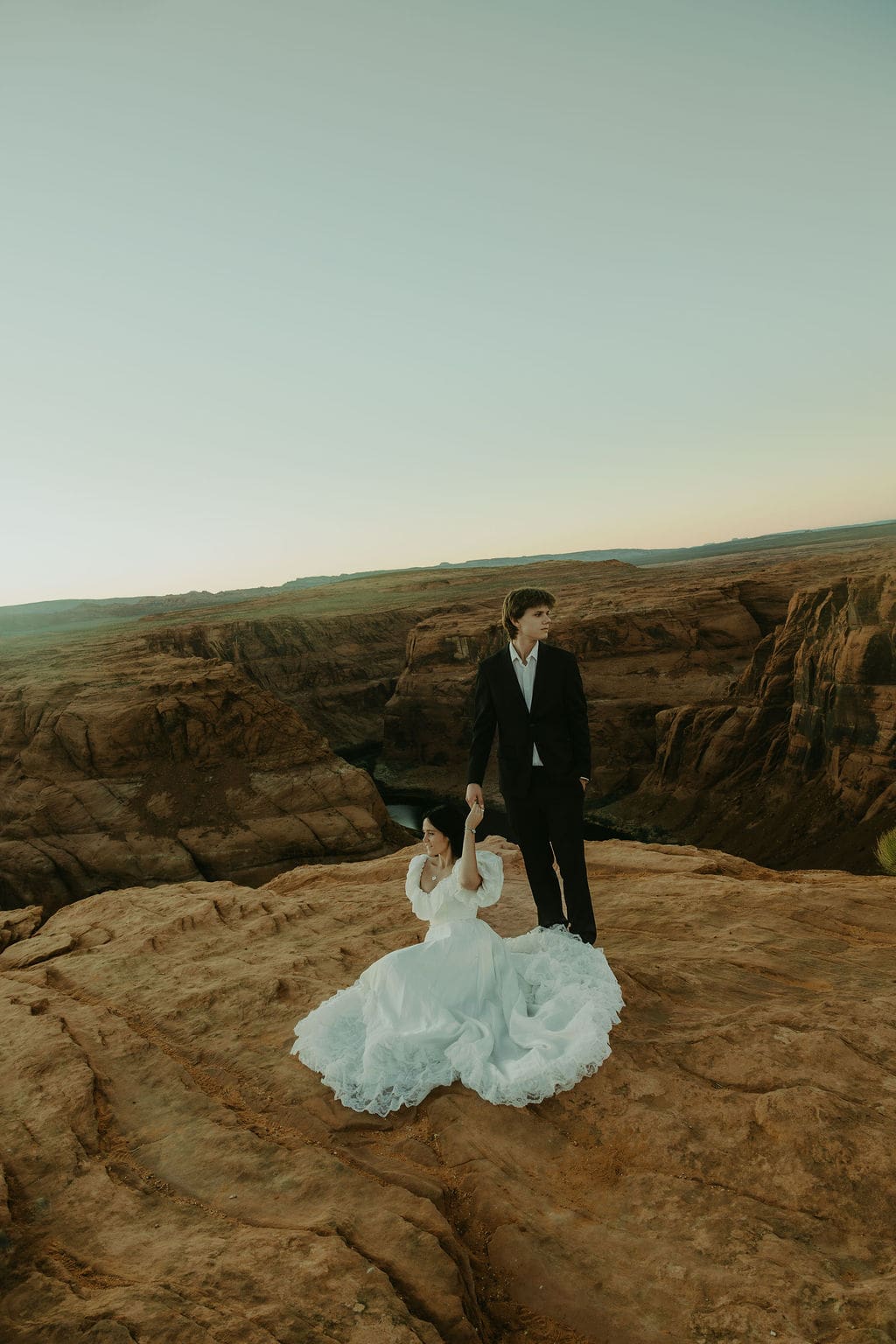 bride and groom pose on the overlook during their horseshoe bend elopement