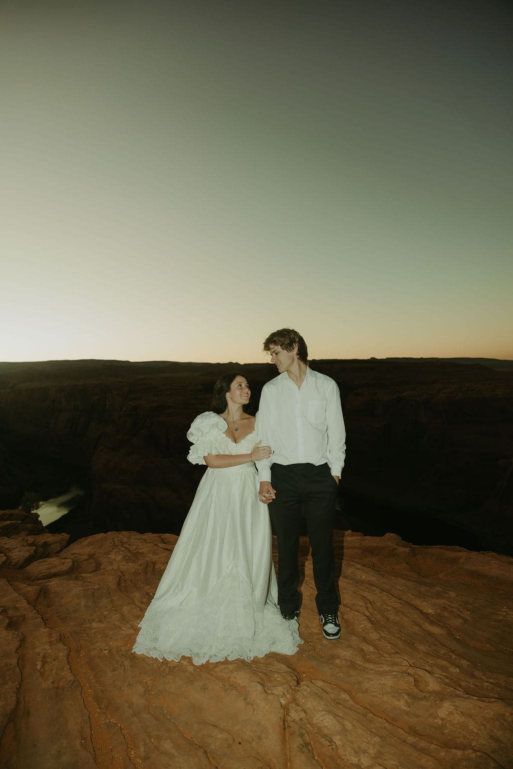 bride and groom pose on the overlook during their horseshoe bend elopement