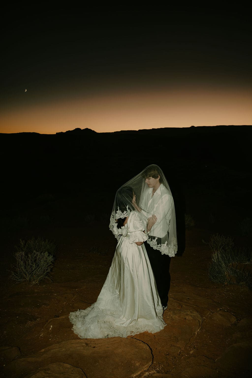 bride and groom share an intimate moment hidden by the veil