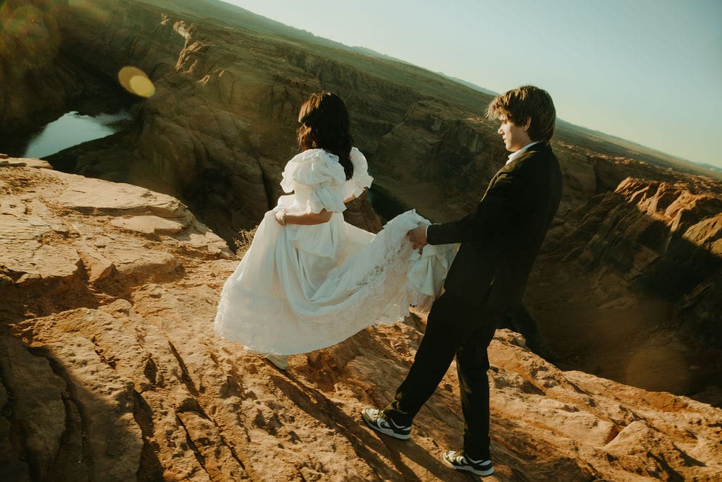 bride and groom pose on the overlook during their horseshoe bend elopement