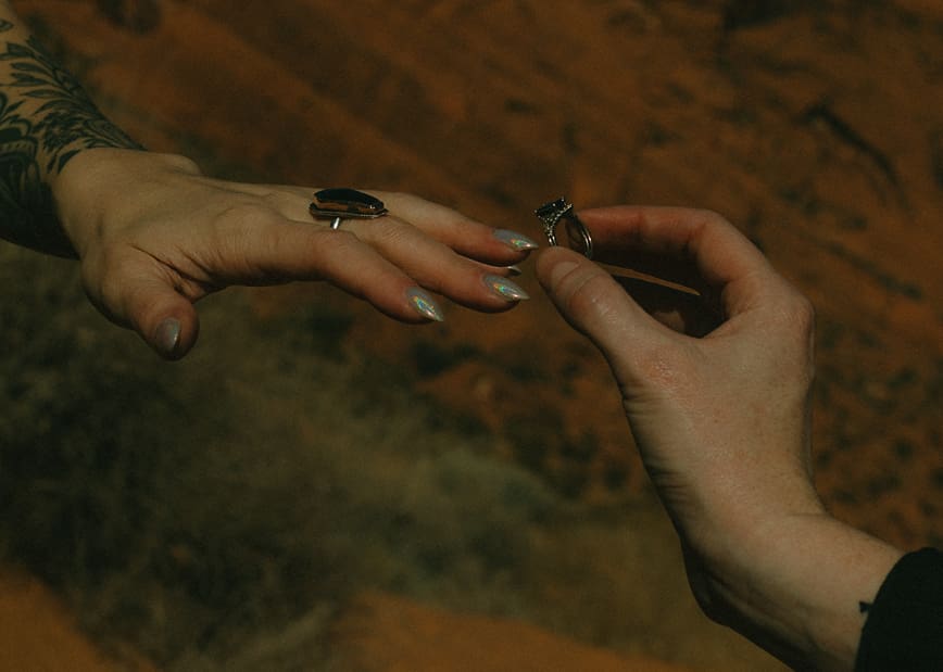 Groom slides the ring on his new brides finger during their beautiful elopement ceremony