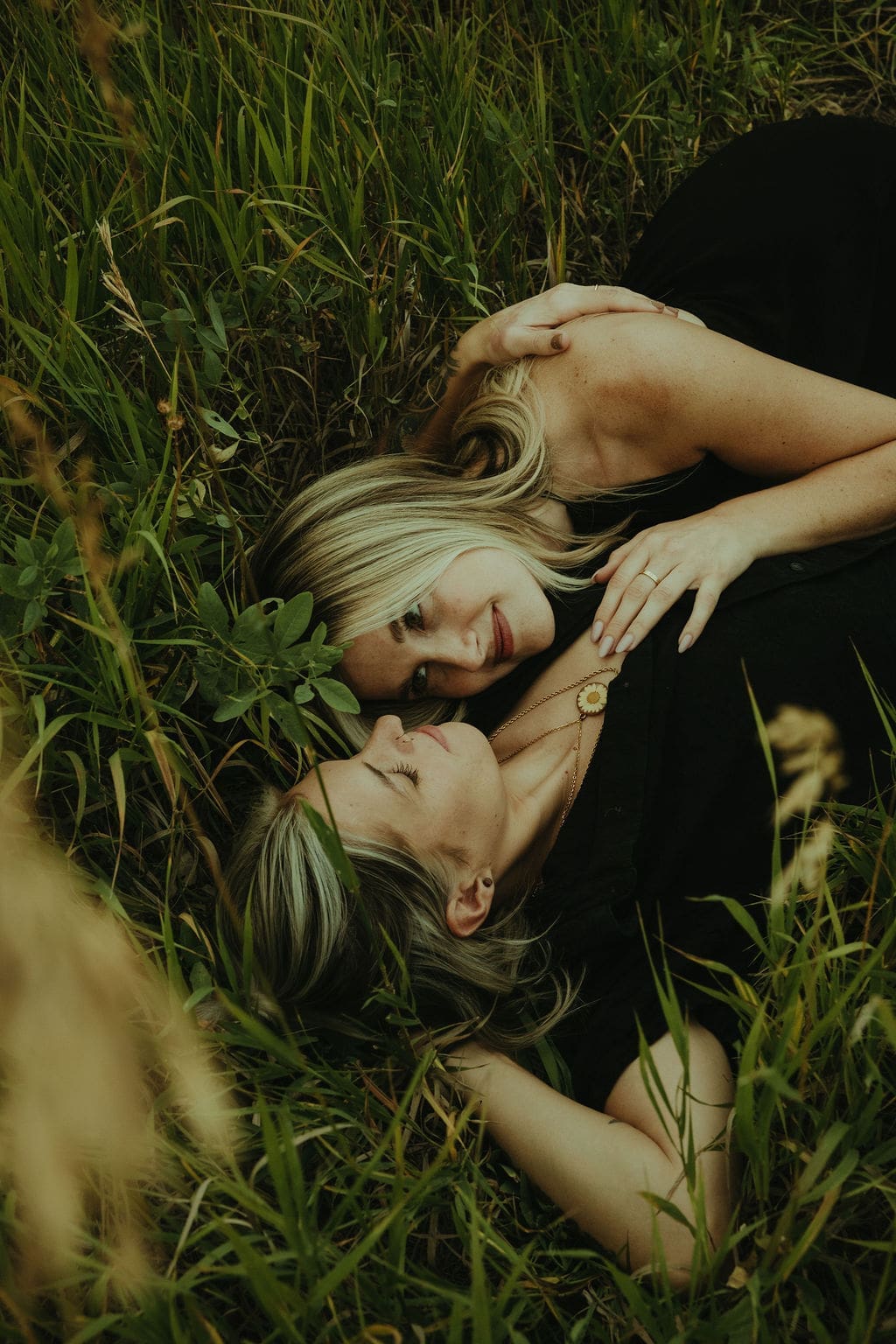 couple lie in a field together during their outdoor engagement photoshoot
