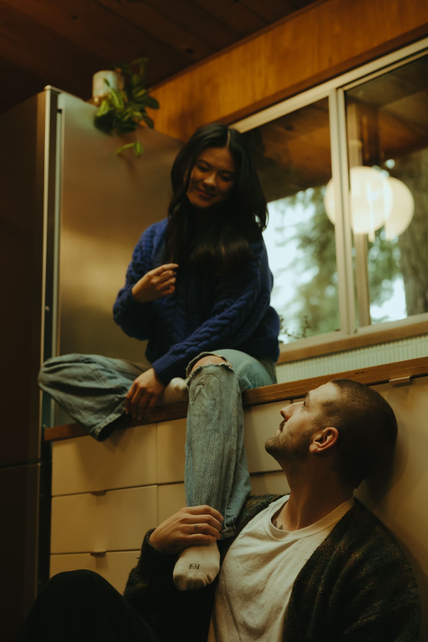 in home couples photoshoot where the couple sits in the kitchen