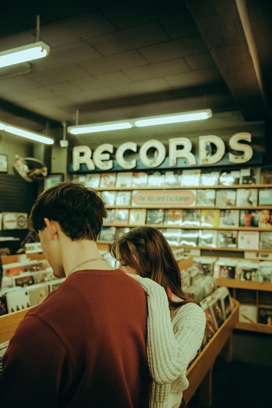 couple pose together during their photoshoot in the record store