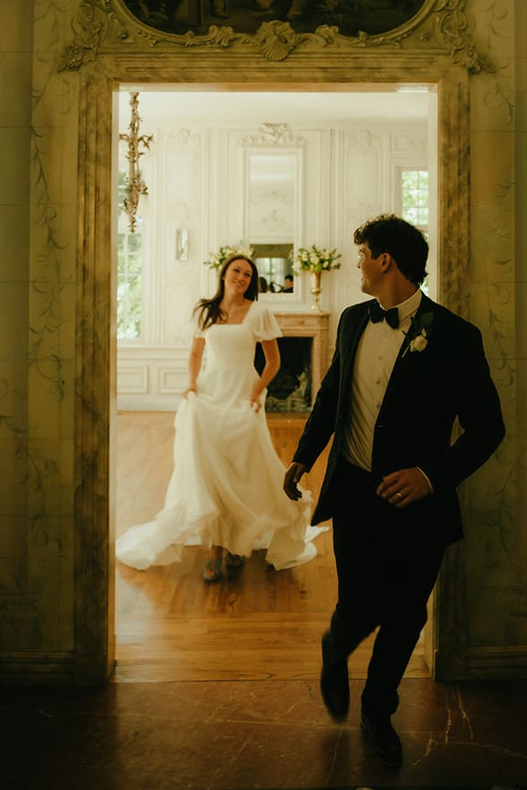 bride and groom run through the house during their classy indoor wedding day captured by southern Utah photographer Kennedi Brooke